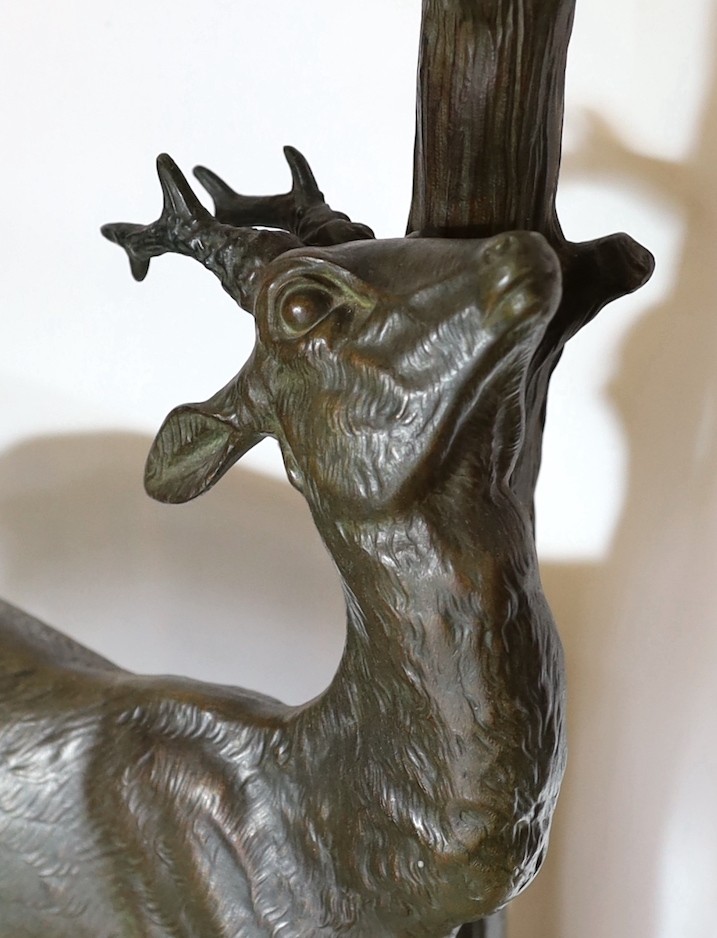 A 1930s French bronzed spelter and marble model of a deer standing beside a tree trunk, signed Cham, height 60cm. width 49cm